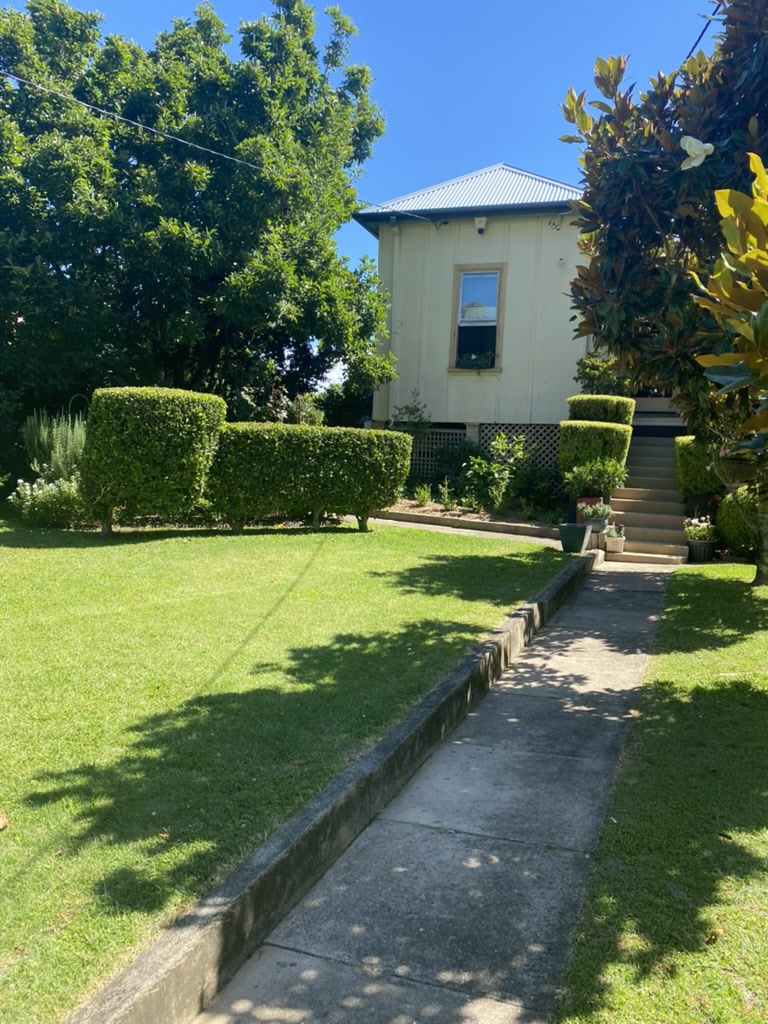 A trimmed lawn and garden path leading up to a home's front steps