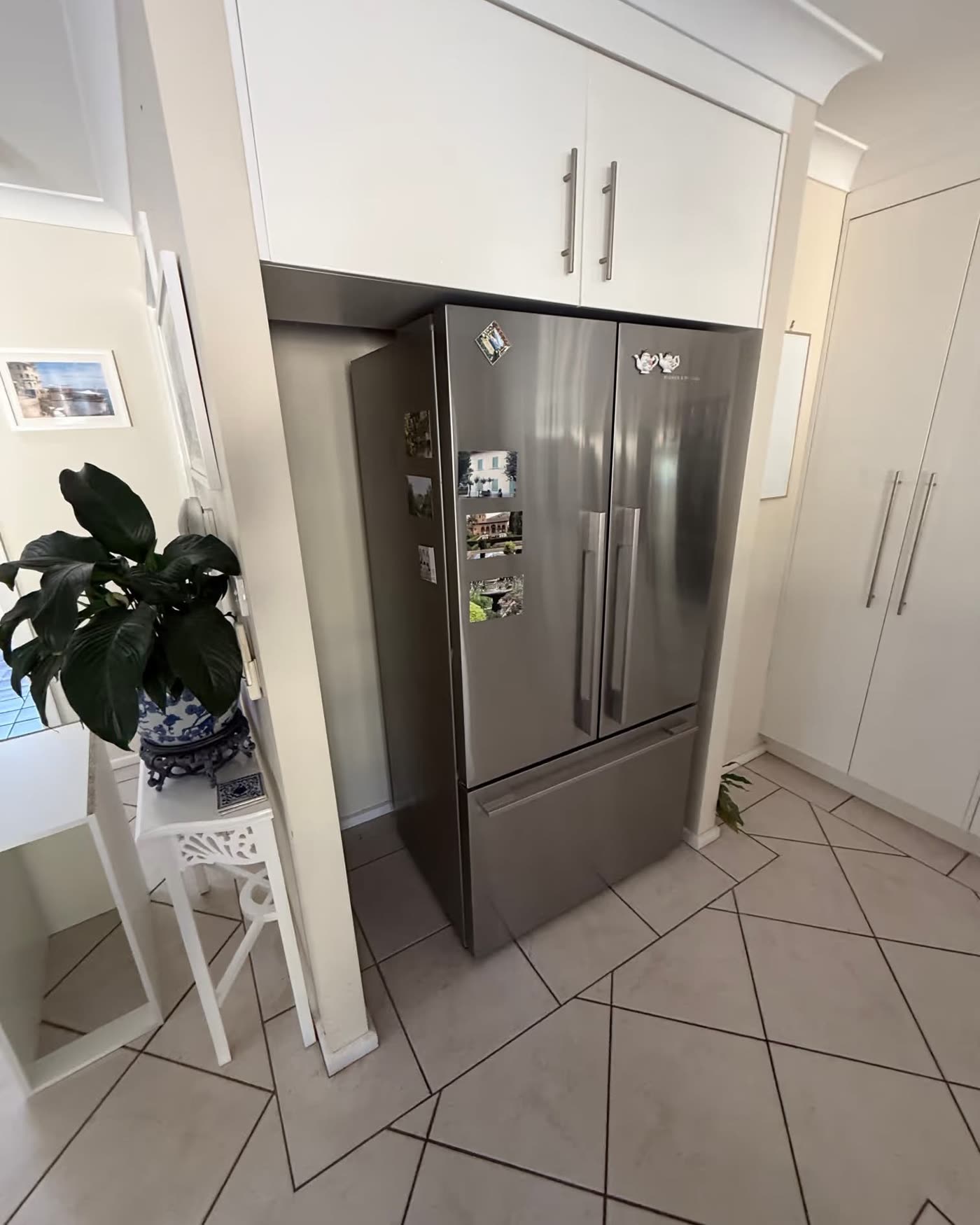 An empty gap beside a fridge