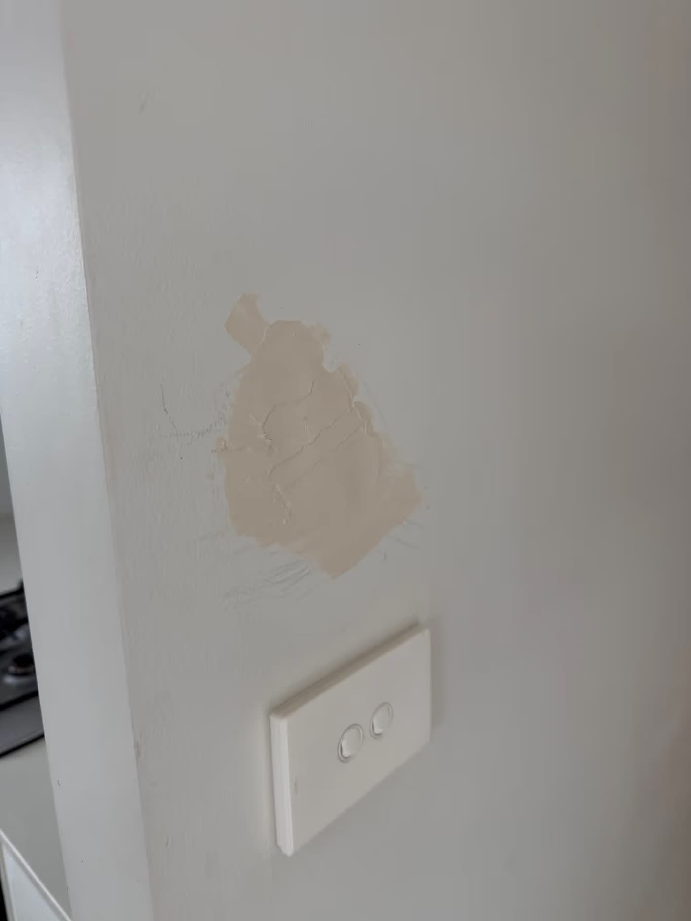 A wall needing patching near a kitchen