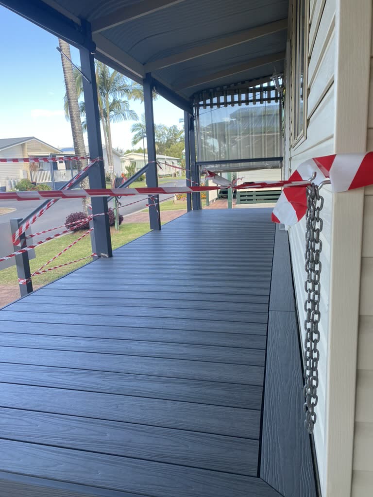The same spot after the job: a finished composite deck and new balustrade running along the house