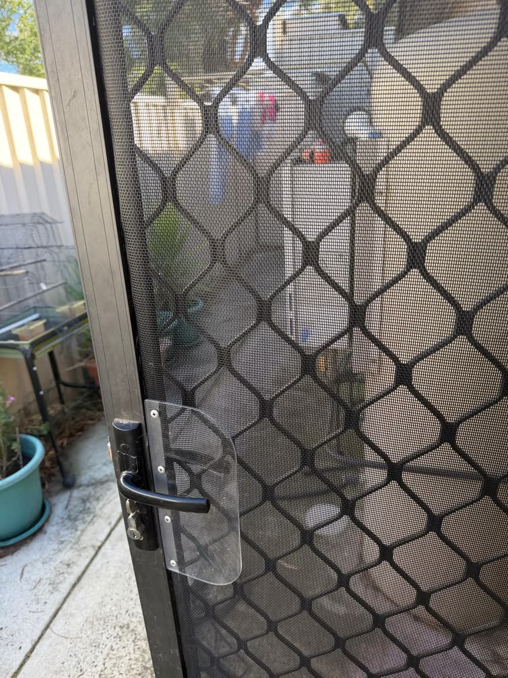 A repaired security screen door with a new security plate and handle fitted